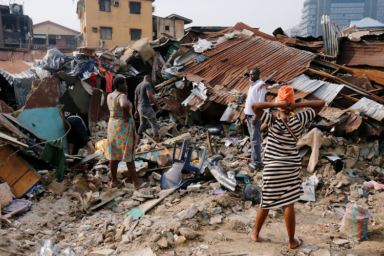 A woman searches for belongings at the site of a collapsed building in Nigeria's commercial capital of Lagos, Nigeria, on March 14 2019.