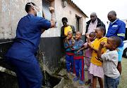 A health worker teaches children how to wash their hands during door-to-door testing in Umlazi, near Durban, on April 4. Health workers, children, parents and the elderly are particularly vulnerable to the psychological impact of the pandemic and the lockdown.