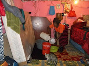 Nosunset Tshemese tries to remove water from her shack. 