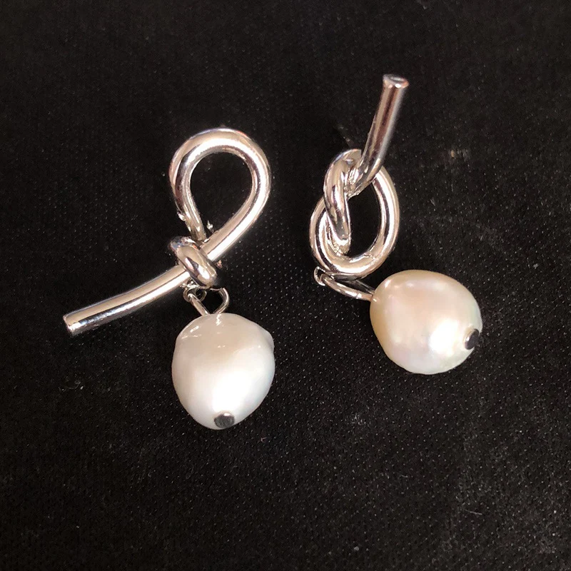 Brincos de pérola com nó assimétrico e versátil. Adicione um toque de elegância e estilo a qualquer look com estas eardrops da moda.