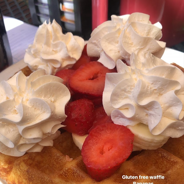 Gluten free waffle with strawberries, bananas, and whipped cream.