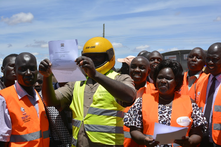 Vice Chancellor of the University of Eldoret Professor Teresia Akenga with boda boda riders at Moiben after issuing them with licenses after one month NTSA training