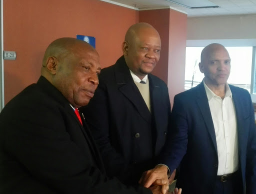 Former Bafana Bafana coach Shakes Mashaba (left) and South African Football Association CEO Dennis Mumble (right) shake hands after reaching a settlement at the CCMA offices in Harrison Street, Johannesburg. They are joined by CCMA commissioner Hlalele Molotsi. PICTURE: Mahlatse Mphahlele