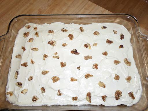 Photo of Pineapple Cake with Cream Cheese Frosting topped with a few chopped walnuts.