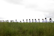 Men queue during an offering session at Ekuphakameni Nazareth Baptist Church on Nhlangakazi mountain.