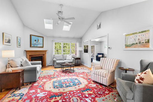 Living room with fireplace and colorful rug in this luxury house for sale in Dartmouth ($745,000)