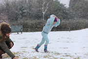 Kathrine Williams and her daughter Katie, aged 5, play in the snow, 10 July 2023, at Jackson Dam in Alberton, South of Johannesburg.  