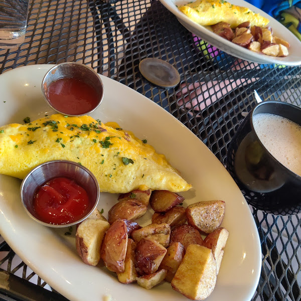 An omelette, breakfast potatoes, and an oatmilk chai-tea.