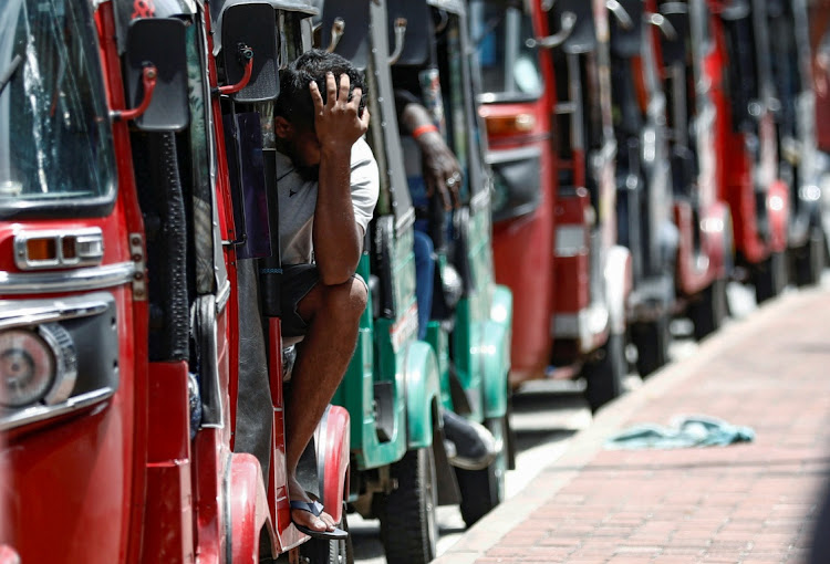 A man waits inside a three-wheeler near a line to buy petrol from a fuel station, amid the country's economic crisis, in Colombo, Sri Lanka, May 23, 2022.