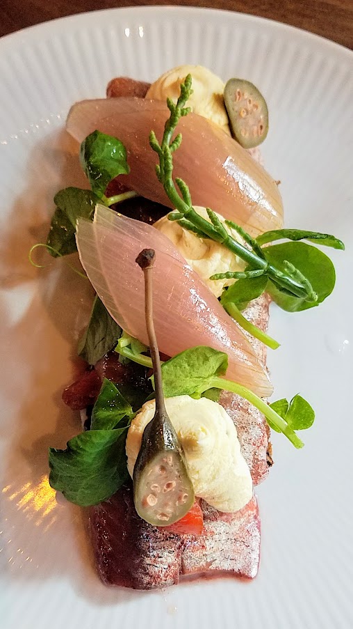 Restaurant Palaegade in Copenhagen offering traditional Danish smørrebrød of Red pickled herring with rosehips, creme fraiche, and pickled onion