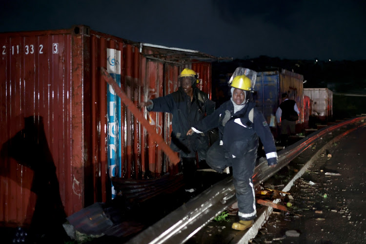 Firefighters hard at work following the heavy downpour at Inanda, Durban.