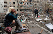 Residents gather in a courtyard near a block of flats heavily damaged during Ukraine-Russia conflict in the southern port city of Mariupol, Ukraine. 