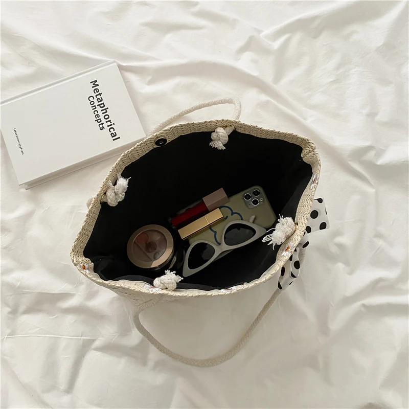 Sac de plage femme simple avec fleurs tissées, parfait pour vos journées d'été. Emportez facilement vos essentiels avec style et confort.