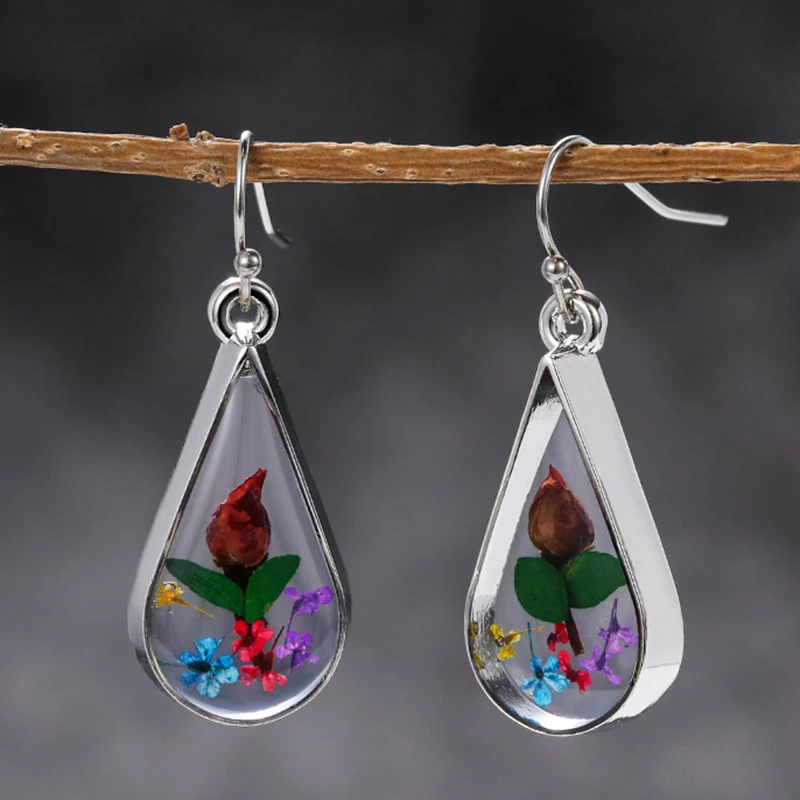 Creatieve oorhangers met gedroogde bloemen en waterdruppels