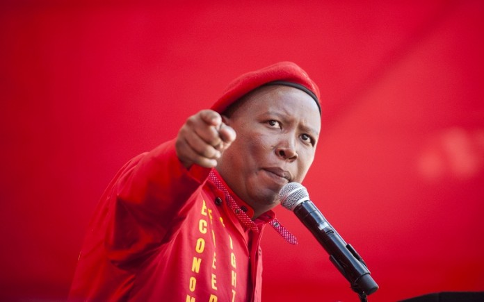 EFF leader Julius Malema told a rally in the Free State, 'We will not only fight [the police] at the picket lines. We will fight them in their homes, with their own families. We are not scared of the police.'