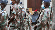 A homeless woman looks on as final rehearsal preparations take place ahead of Thursday's state of the nation address at the Cape Town city hall.