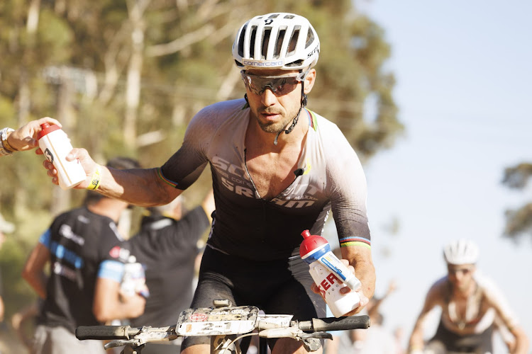 Nino Schurter grabs a bottle during stage four of the Absa Cape Epic Mountain Bike stage race around CPUT, Wellington, on Thursday