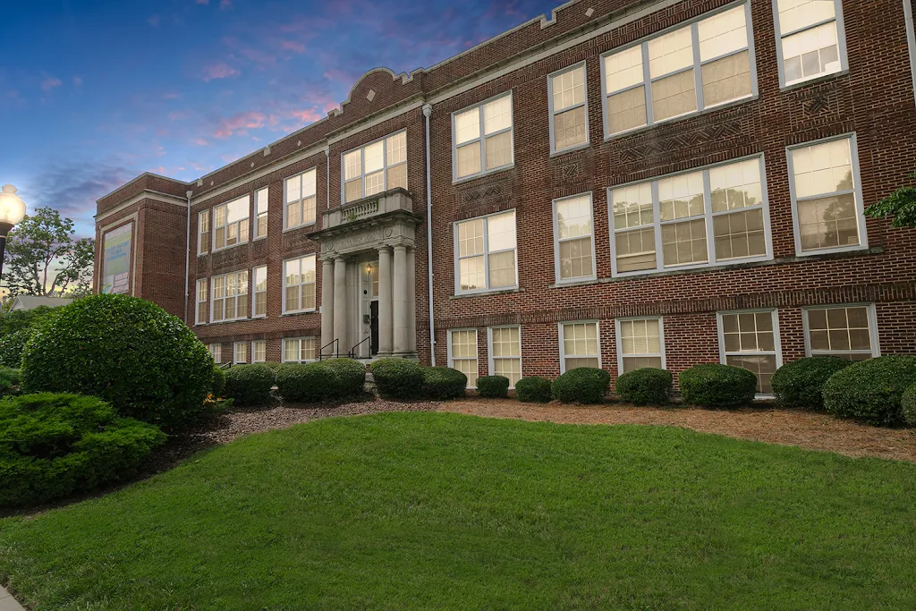 The School at Spring Garden red brick building surrounded by green space at dusk