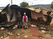 Primary image caption: Outside their parents’ burned house are Albert Williams and Francina Mohlakoane. Their mother was killed in the attack.