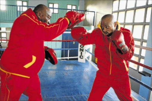 Boxing trainer Eugenne Khanyile, left, takes his charge Sibusiso Twani on pads. PHOTO: MOHAU MOFOKENG