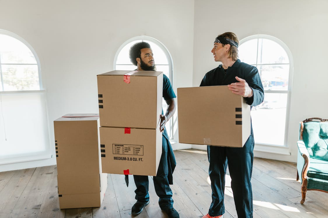 Dicas para mudança: homens trazendo caixas para casa nova