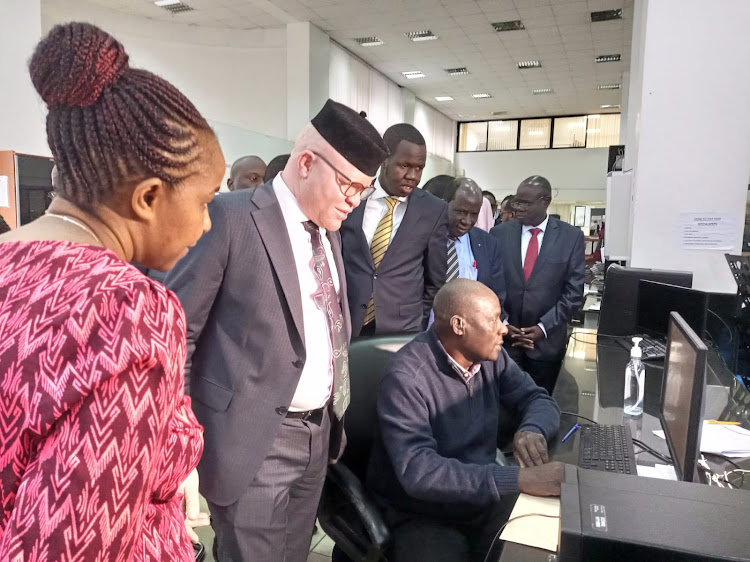 Webuye East MP Wanyonyi Pepela being taken through the NHIF customer care process at the call centre on Thursday, November 24, 2022