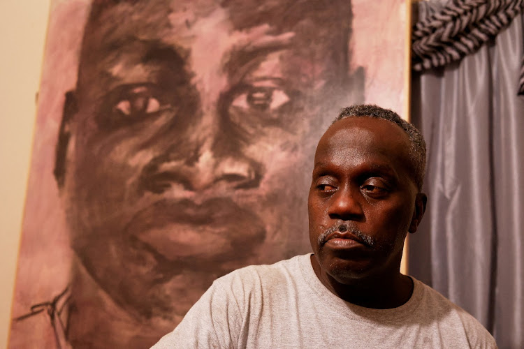 Marcus Arbery is pictured in his son, Ahmaud Arbery's bedroom with portraits that were given as a gift after he was slain in Brunswick, Georgia, US October 11, 2021.