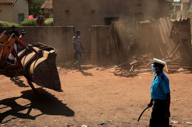 Residents watch as municipal police demolish illegal structures during a nationwide lockdown to curb the spread of Covid-19 in Harare, Zimbabwe, on April 24 2020.