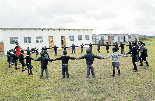 CIRCLE OF HAPPINESS: Children play outside their new classrooms at Fort Warwick Primary School. A Swiss volunteer raised funds for them to be built Picture: SIBONGILE NGALWA