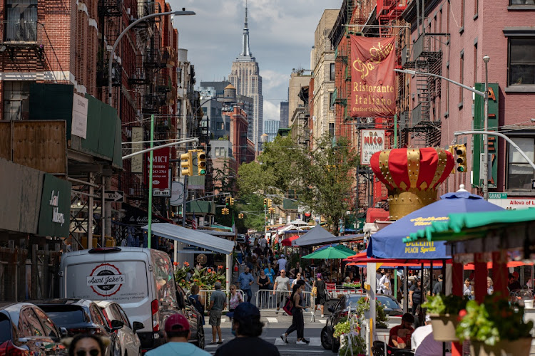 People walk down a street lined with outdoor seating for restaurants in the Little Italy neighborhood of Manhattan, in New York, the US, July 18 2021. Picture: REUTERS/JEENAH MOON