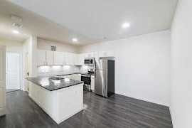 Kitchen with dining room area, wood-inspired flooring, stainless steel appliances, subway tile backsplash, and white cabinets