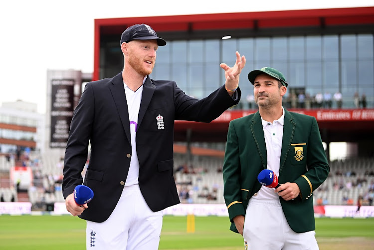 England captain Ben Stokes tosses the coin as SA counterpart Dean Elgar looks on ahead of day one of the second Test match at Old Trafford on August 25 2022.