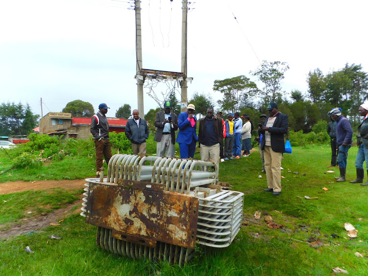 Activist and former Rurii MCA Wahome Kamoche (centre,holding chin) and KPLC security team view the power transformer that was vandalised at Rurii town on Sunday night