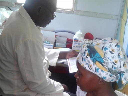 A mother and her child being attended to inside a mobile clinic in Kitui.Photo by Musembi Nzengu