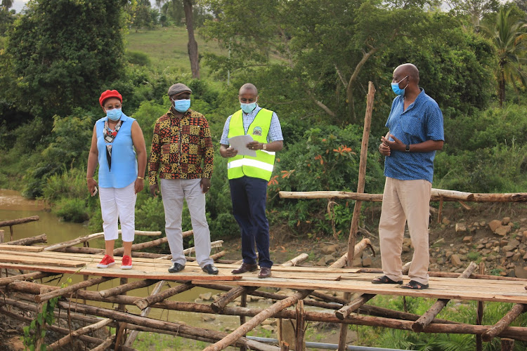 Members of the special funds accounts of the national assembly Faith Wairimu, Chairman Murungi Kithuri, and Erastus Kivisu with KERRA Engineer (in reflector) at the Chengoni bridge construction site on Monday 9 November