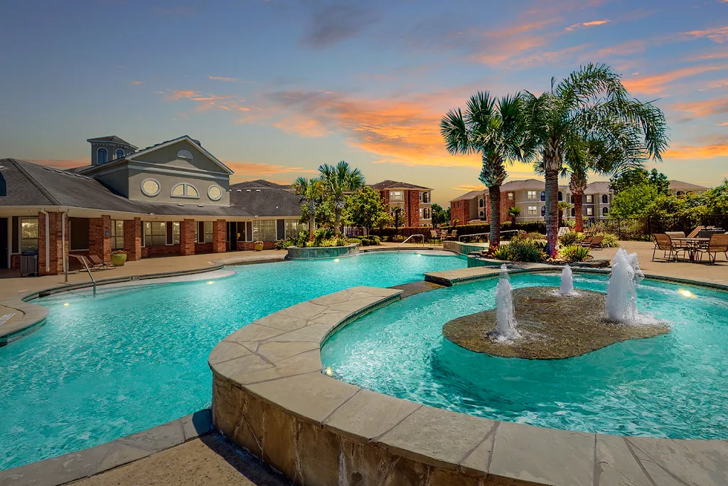 Reserve at Tranquility Lake's resort-style swimming pool with fountain at dusk