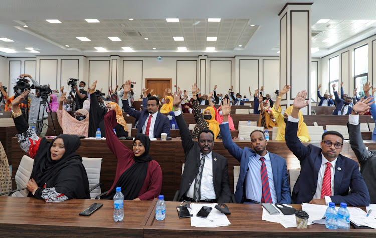 Somali legislators of the lower house of parliament raise their hands to vote to extend President Mohamed Abdullahi Mohamed's term for another two years to let the country prepare for direct elections, in Mogadishu, Somalia April 12, 2021.