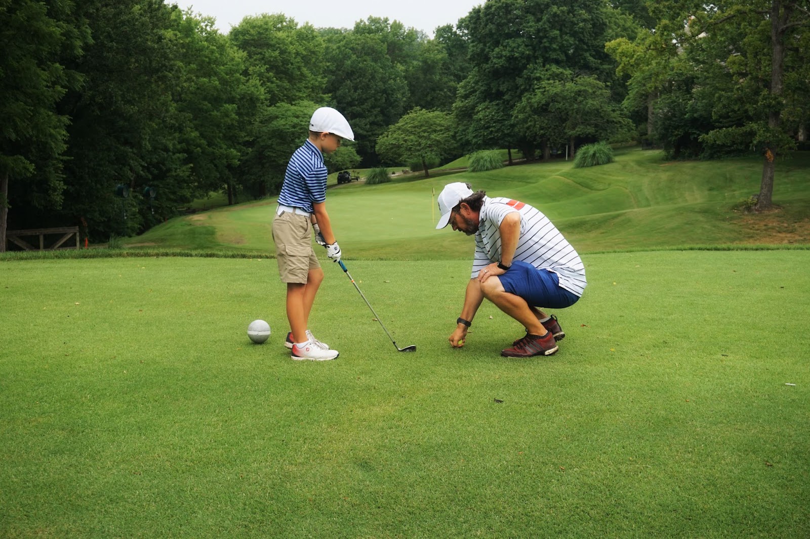 Dad teaches son to play golf