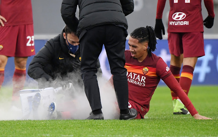 AS Roma's Chris Smalling is assisted by medical professionals after sustaining an injury