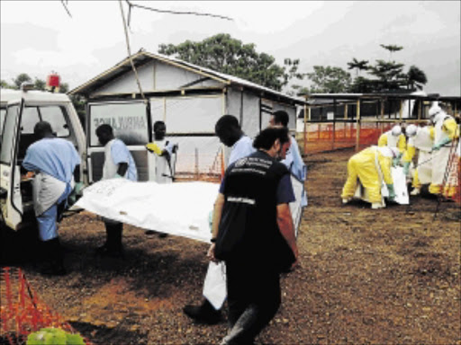 DEADLY: Volunteers evacuate bodies from a health a centre in Kailahun, Sierra Leone. Troops have been deployed in Sierra Leone and Liberia to quarantine communities hit by the virusPhoto: REUTERS