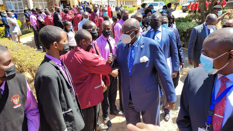 Education CS George Magoha interacts with students and teachers at Machakos Boys School on Monday.