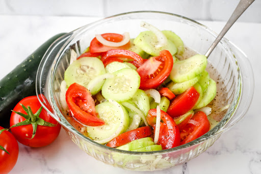 Marinated Cucumbers, Onion, and Tomatoes in a serving bowl.