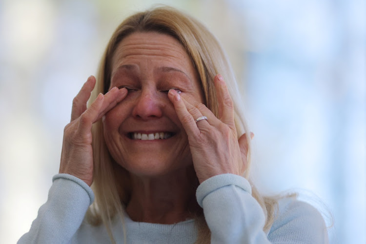 Wendy Nelson, whose mother died from Alzheimer's disease and father suffers from it, becomes emotional when talking about the potential of also getting the disease and how that would affect how she would want the end of her life to play out, during an interview with Reuters at her home in Foxborough, Massachusetts, U.S., March 21, 2023. A genetic test through 23andMe shows that Wendy carries two APOE4 gene variants, and her three daughters each carry one APOE4 gene variant, indicating an increased risk of Alzheimer's disease.