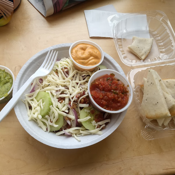 Hummus w/ pita and a bowl with rice, chicken, cheese, bacon, onion, cucumber, and garlic aioli.