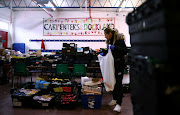 Dionne Tracey sorts food items ready to be delivered to local residents at a food bank in the Docklands Settlements Community Centre, as the spread of the coronavirus disease (Covid-19) continues, in east London, Britain. File photo 