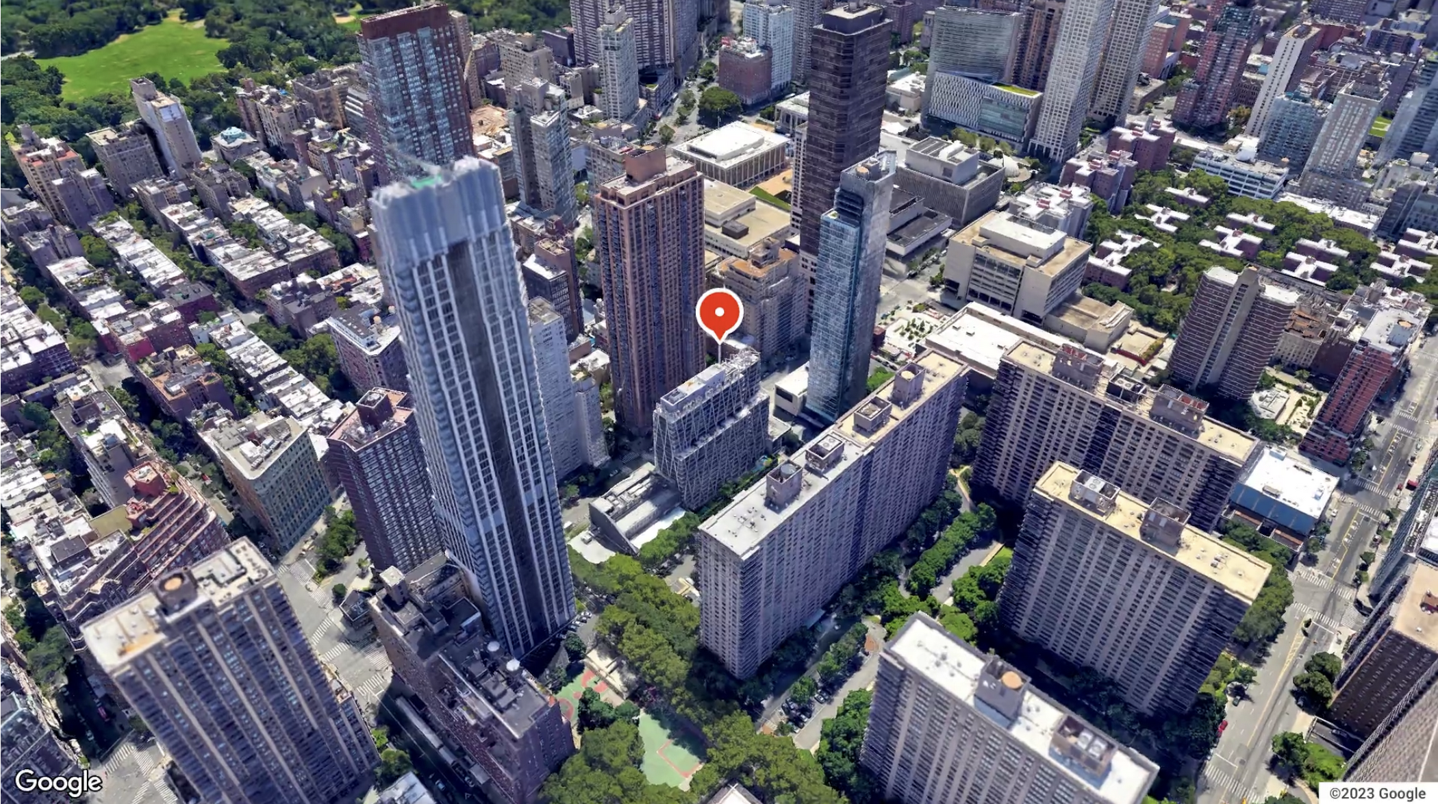 Aerial view of a city with a pin atop an apartment building available for rent. 