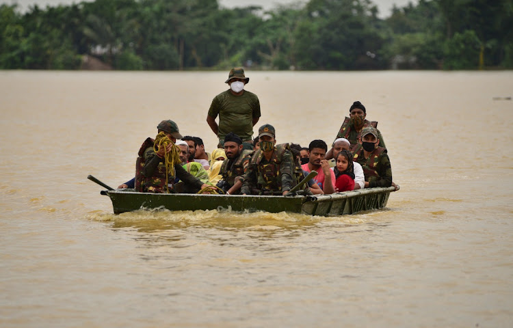 Indian Army soldiers evacuate people from flooded area to a safer place after heavy rains at a village in Hojai district, in the northeastern state of Assam, India, June 18, 2022.