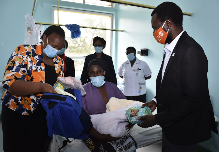 Beth Maina gifts new mother Ann Wanjiru with the Mama Care kit