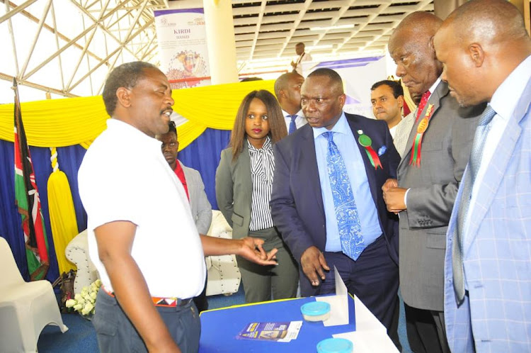 Kenya National Chamber of Commerce and Industry president Richard Ngatia (centre) during a visit to a Small and Medium Enterprises exhibition last year at the Nairobi International Trade Fair..