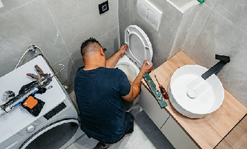 Plumber installing a new toilet seat during a modern bathroom renovation project.
